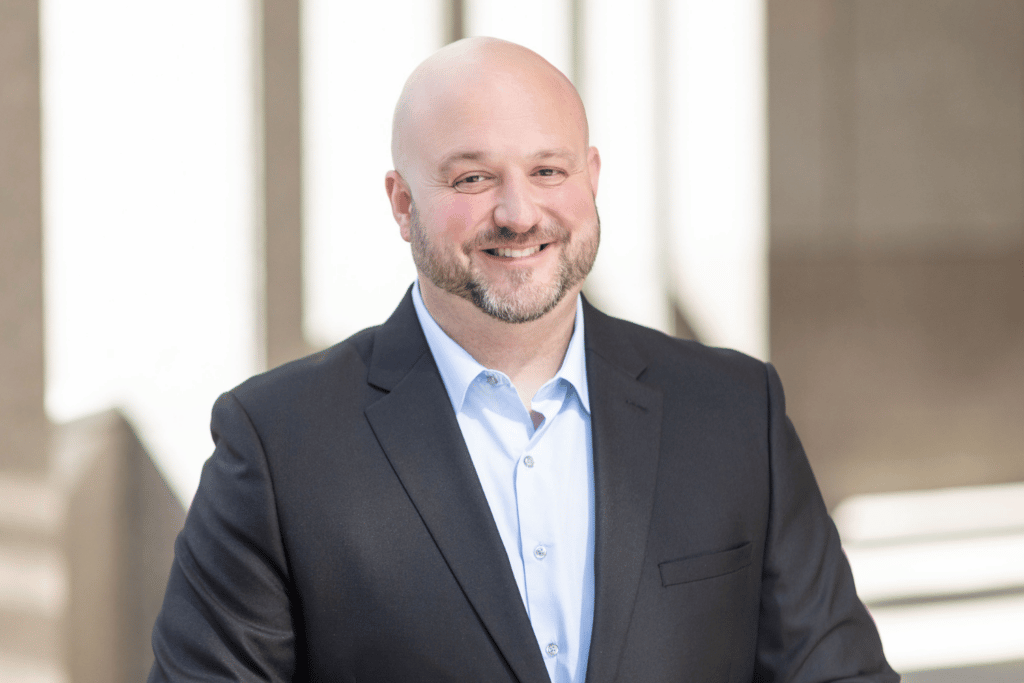 Photo of man wearing a suit and smiling