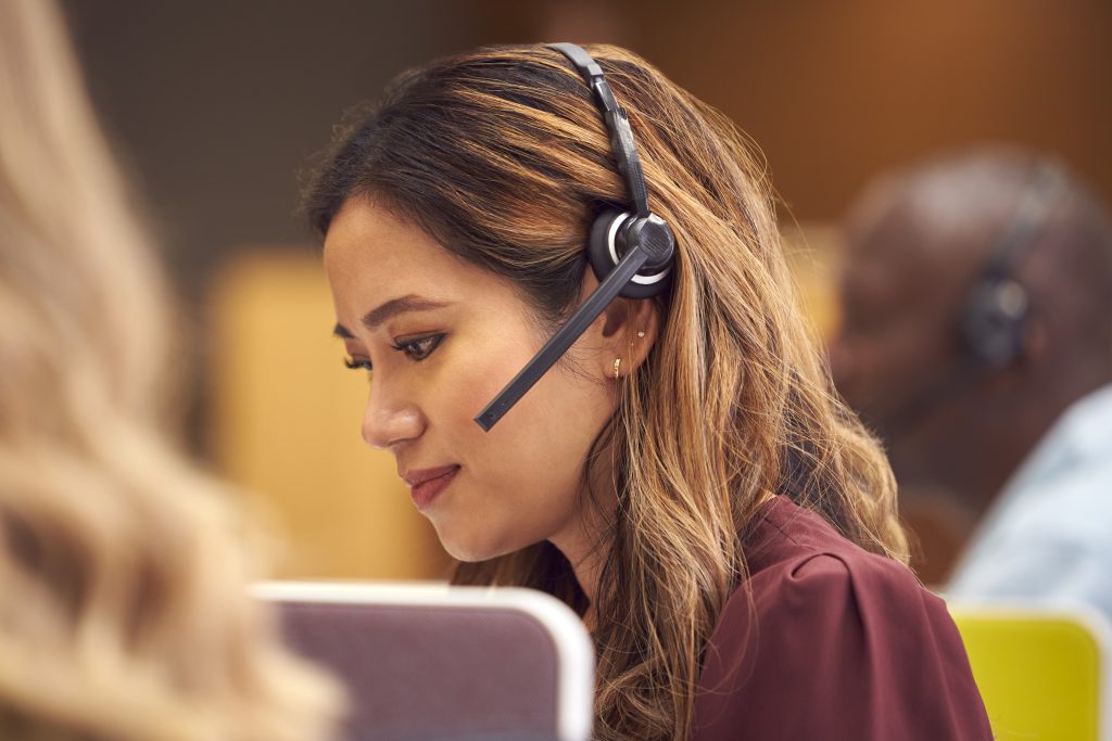 Young woman with brown hair talking into a headset