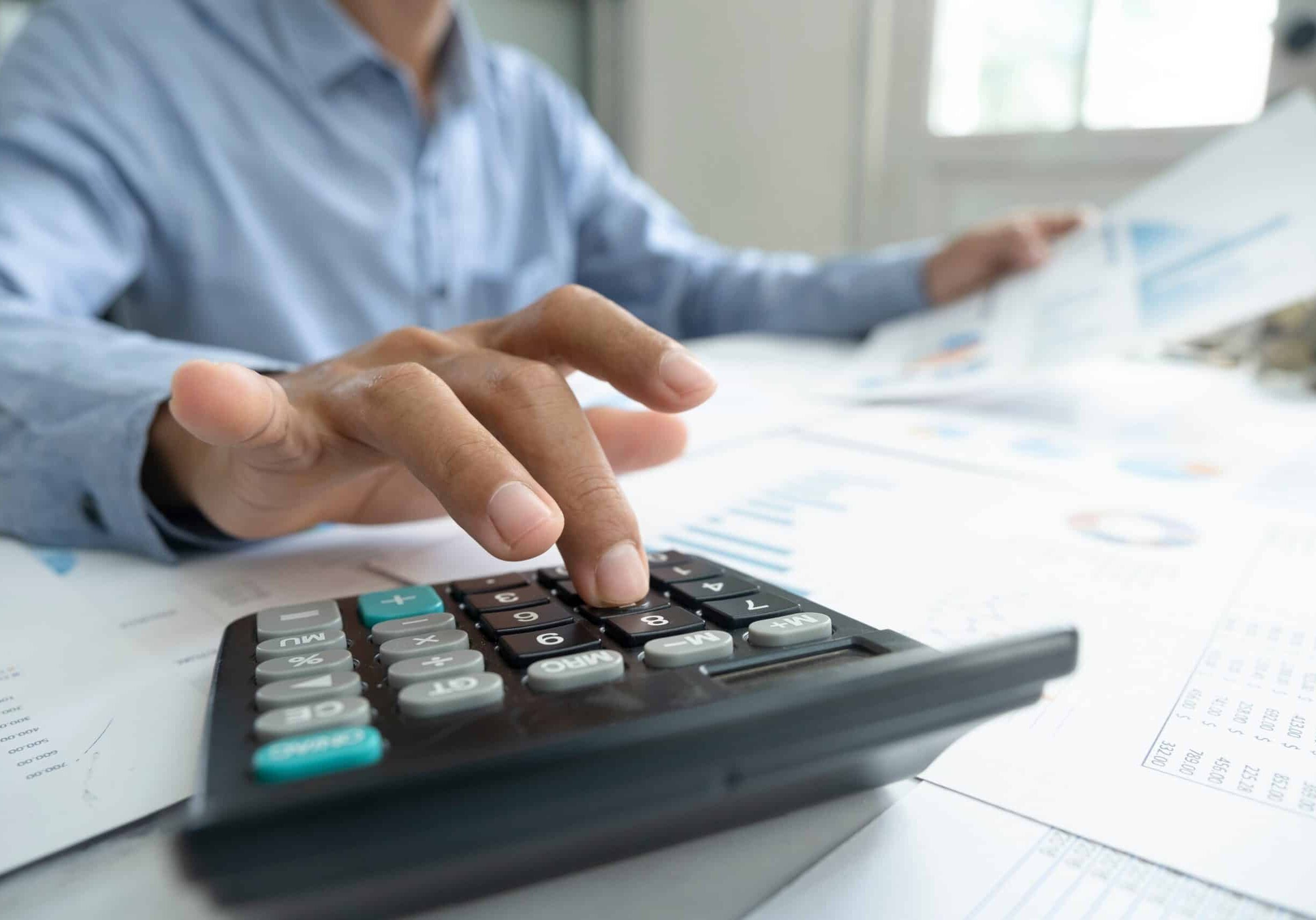 Accountant or banker calculate the cash bill. looking over papers and using calculator