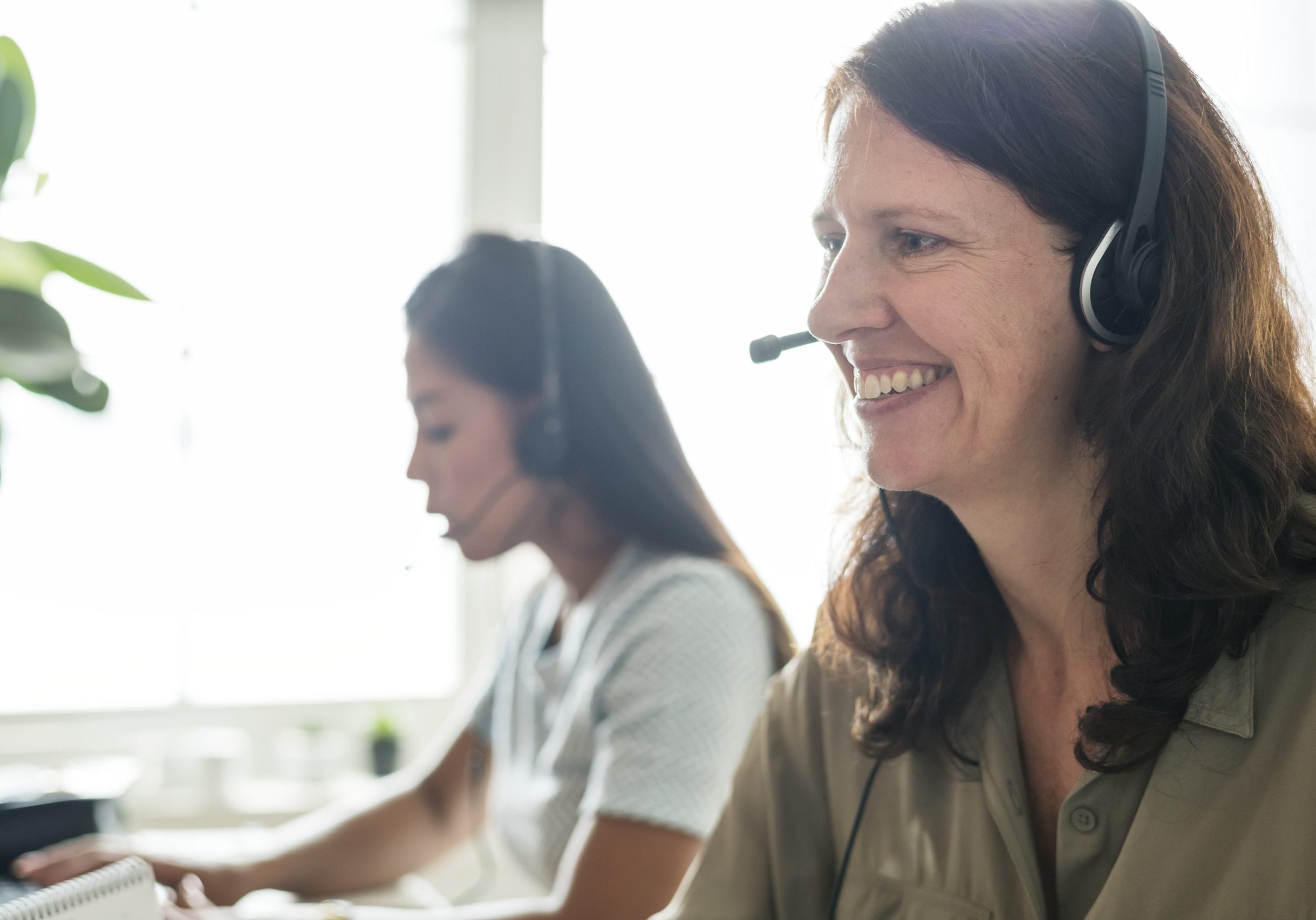 Customer service Brown haired lady smiling and talking on headset