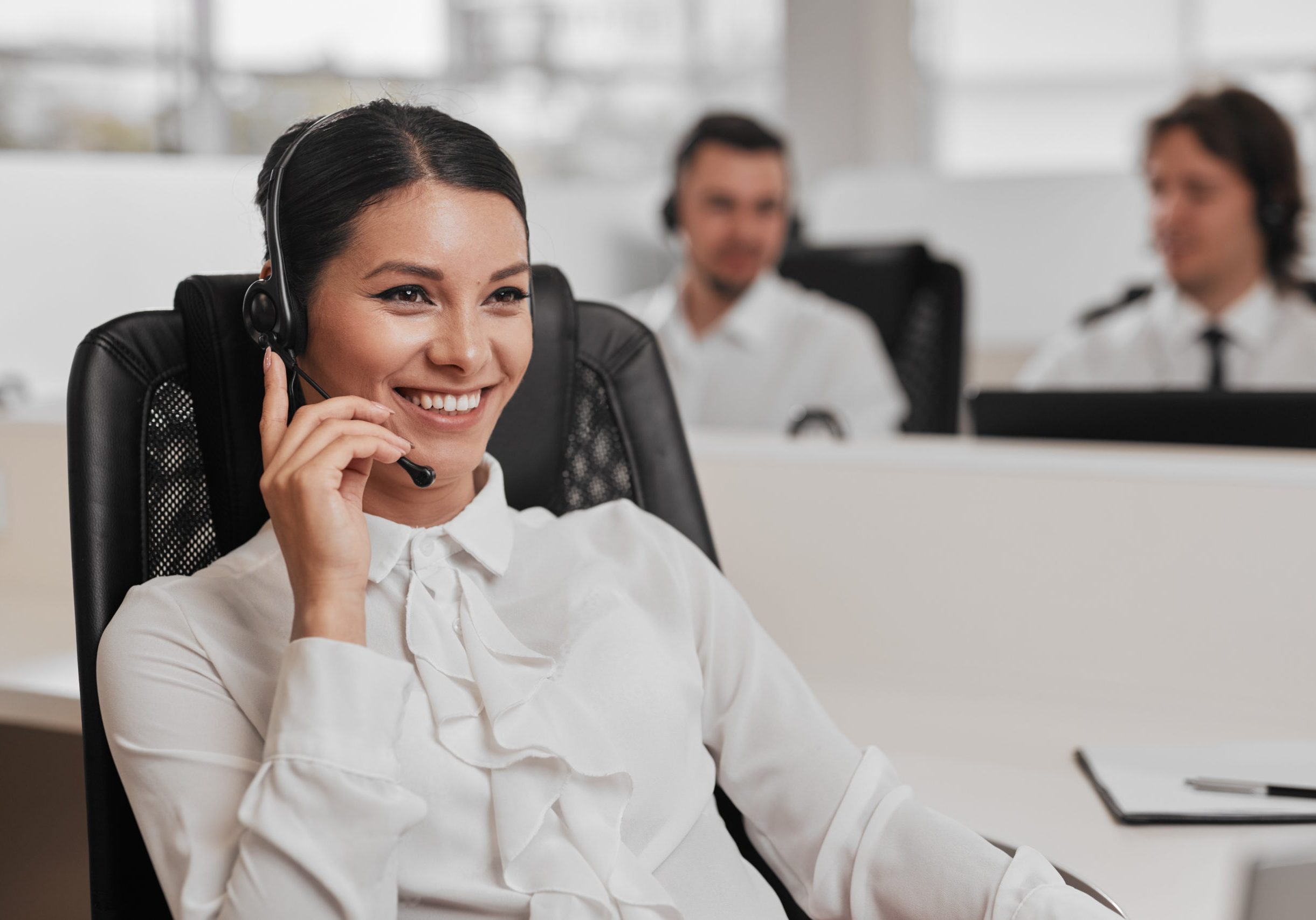 Hispanic customer service agent in office Lady with black hair smiling and talking into a headset